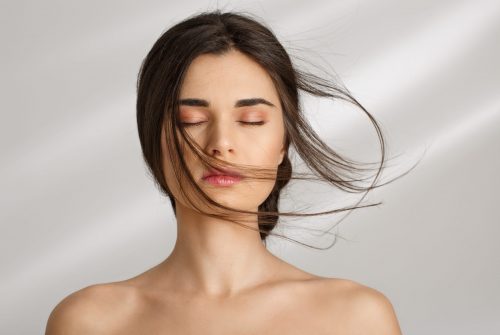 Closeup of beautiful naked woman after spa procedures enjoying herself. Eyes closed. Skin care.